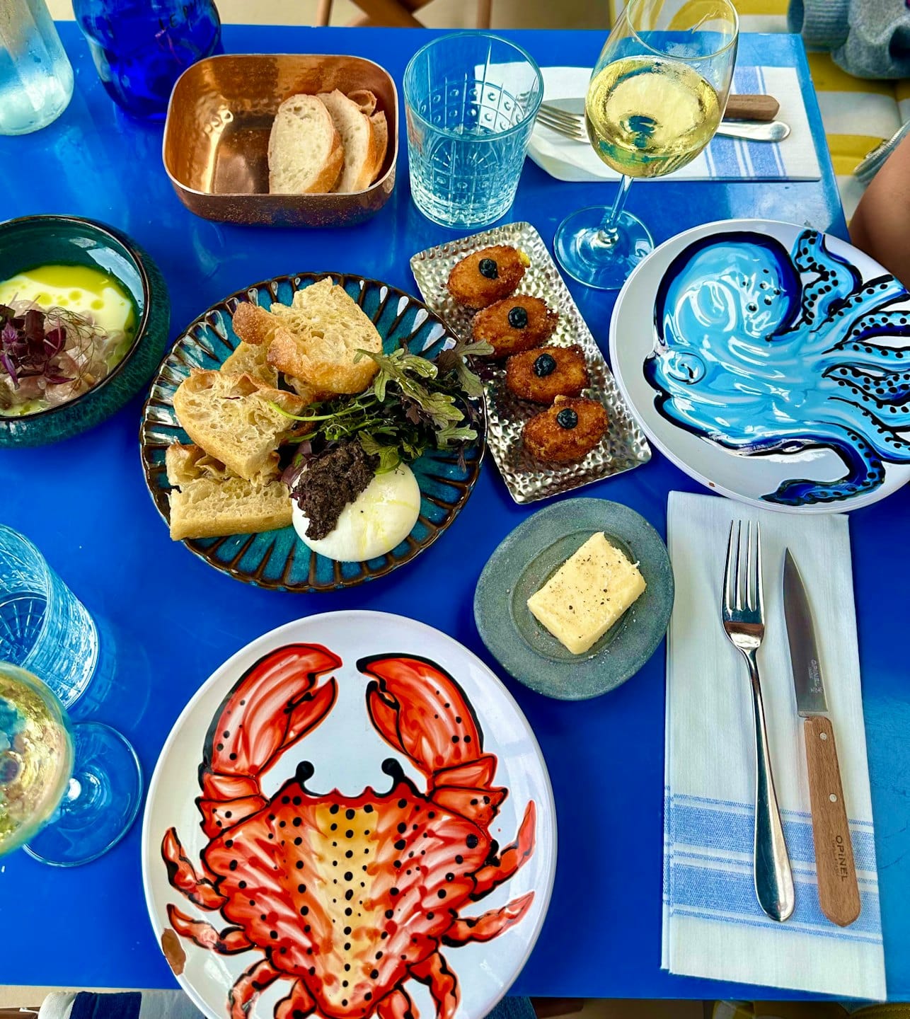 Ein Esstisch voller mediterraner Vorspeisen und Weingläser.